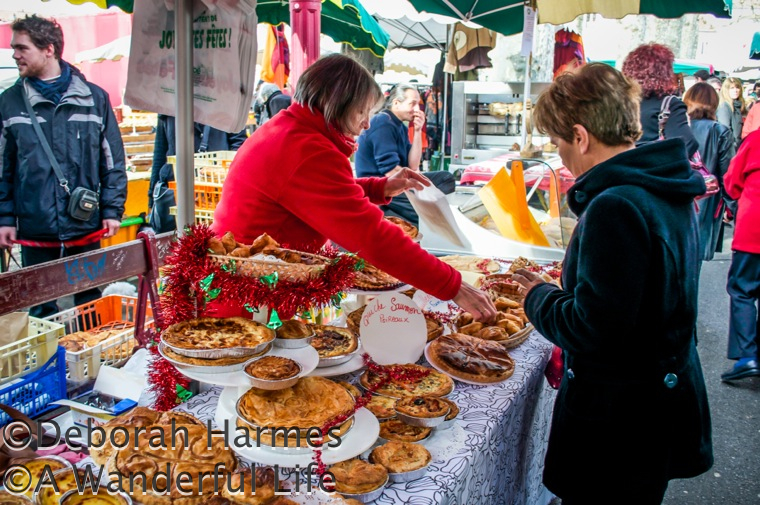 Christmas quiche seller at a busy weekend market in France.